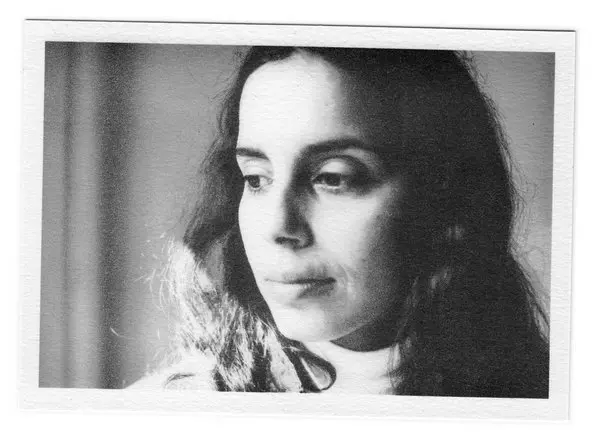 Retrato fotográfico en blanco y negro de Ana Mendieta, de perfil tres cuartos, con la mirada baja.